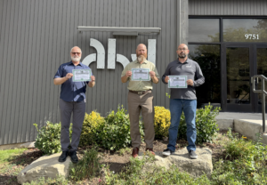 AHJ Engineers leadership team celebrating new ownership certificates: Dave Haugland, Aaron Bonney, and Brian Garner.